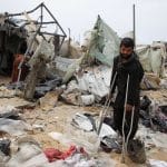 Palestinians inspect a tent camp damaged in an Israeli strike during an Israeli military operation, in Rafah